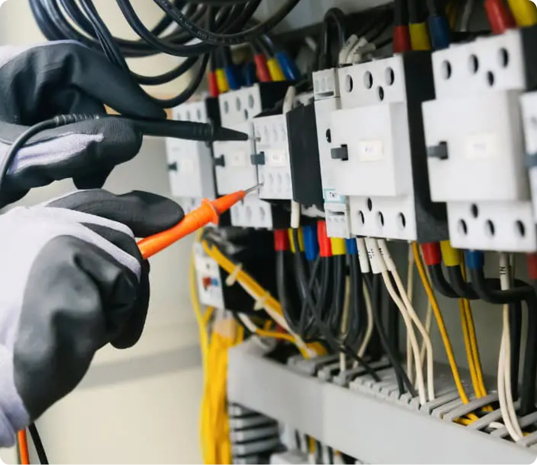 Teste de circuitos com multímetro em quadro de distribuição com terminais identificados e cabos organizados