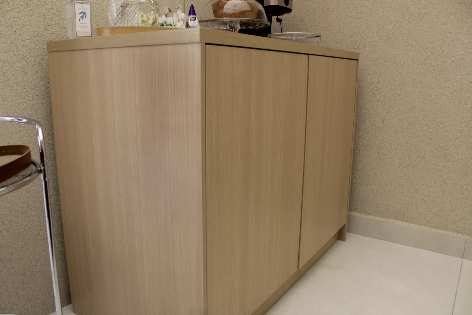 Aparador planejado em madeira clara na recepção do consultório odontológico Veluti